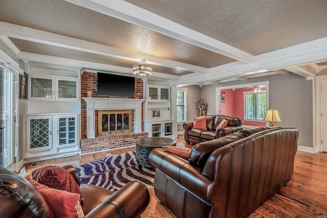77 Stoneledge Dr, Maumelle, AR 72113 - living area with a textured ceiling, wood finished floors, beam ceiling, a fireplace, and a chandelier