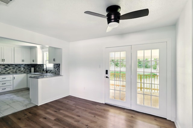 13512 Peters Rd, Cabot, AR 72023 - kitchen featuring a sink, a peninsula, backsplash, ceiling fan, and white cabinets