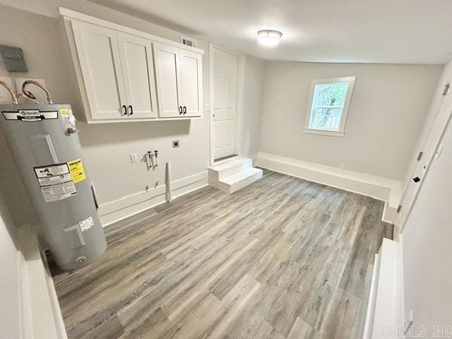 1307 Aplin Ave, Perryville, AR 72126 - washroom featuring electric dryer hookup, electric water heater, cabinet space, light wood-style flooring, and baseboards