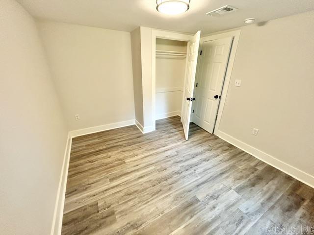 1307 Aplin Ave, Perryville, AR 72126 - unfurnished bedroom with wood finished floors, a closet, and baseboards