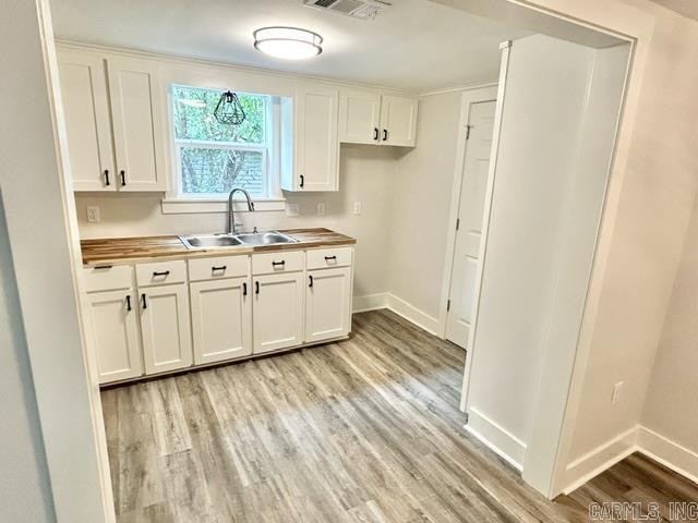 1307 Aplin Ave, Perryville, AR 72126 - kitchen with a sink, wood counters, light wood finished floors, and baseboards