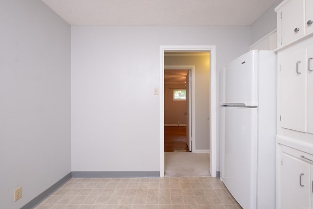 25 Barbara Cir, Little Rock, AR 72204 - kitchen with freestanding refrigerator, white cabinetry, and baseboards
