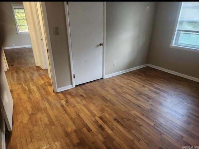 104 W Searcy, Searcy, AR 72082 - unfurnished bedroom with wood finished floors, multiple windows, and baseboards