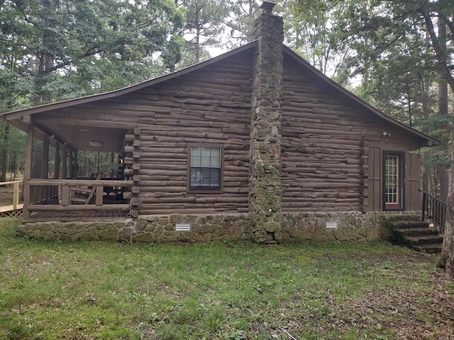 view of property exterior with log exterior, a yard, and a chimney