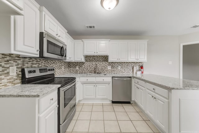 14 Woodbridge, Cabot, AR 72023 - kitchen featuring stainless steel appliances, a peninsula, a sink, decorative backsplash, and white cabinetry