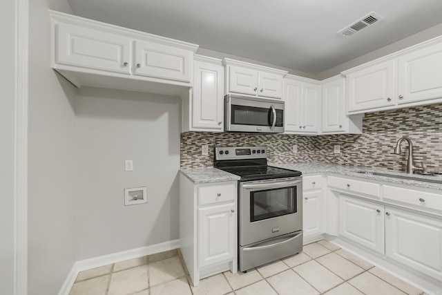 14 Woodbridge, Cabot, AR 72023 - kitchen with appliances with stainless steel finishes, a sink, tasteful backsplash, and light tile patterned floors