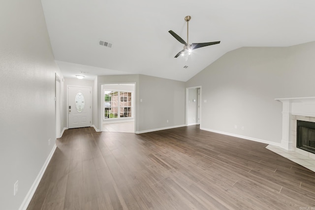 14 Woodbridge, Cabot, AR 72023 - unfurnished living room featuring a ceiling fan, vaulted ceiling, a tile fireplace, wood finished floors, and baseboards