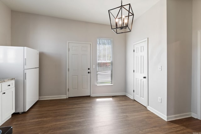 1403 Scott, Conway, AR 72032 - unfurnished dining area with dark wood-style floors, a chandelier, and baseboards