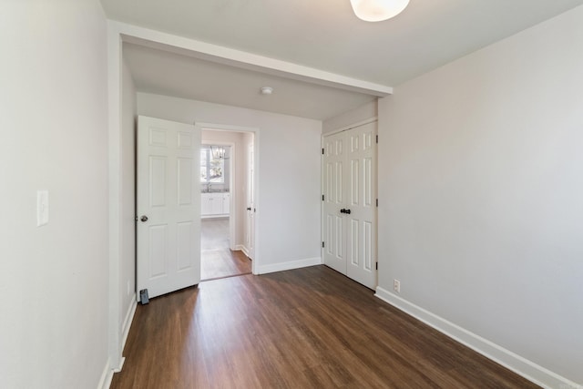 1403 Scott, Conway, AR 72032 - unfurnished bedroom featuring baseboards, dark wood-style floors, and a closet