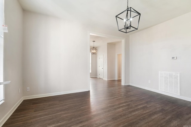 1403 Scott, Conway, AR 72032 - spare room featuring a chandelier, dark wood-type flooring, and baseboards