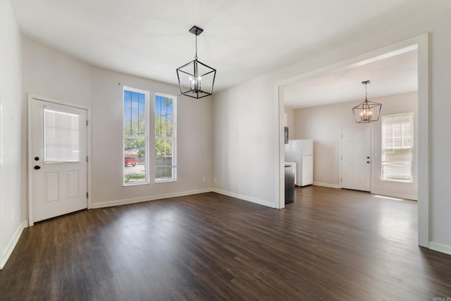 1403 Scott, Conway, AR 72032 - unfurnished living room featuring a chandelier, dark wood-type flooring, and baseboards