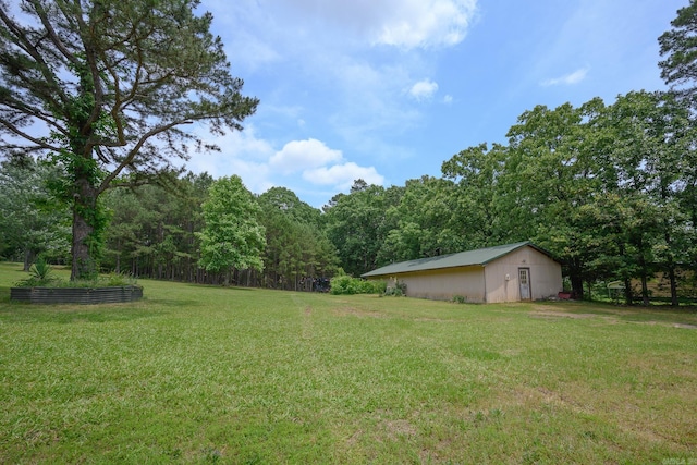 1702 Carolina Dr, Mena, AR 71953 - view of green lawn with a pole building, a view of trees, and an outbuilding
