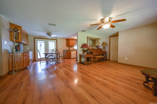1702 Carolina Dr, Mena, AR 71953 - living area with a ceiling fan, light wood-style flooring, baseboards, and a textured ceiling