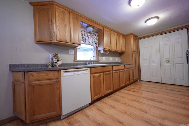 1702 Carolina Dr, Mena, AR 71953 - kitchen featuring white dishwasher, a sink, dark countertops, and light wood-type flooring
