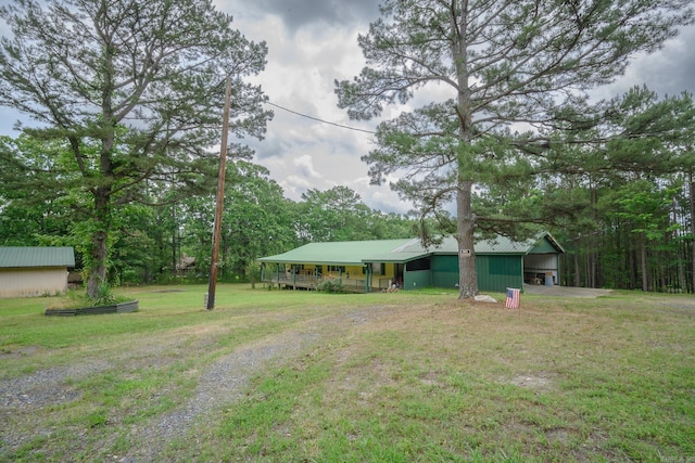 1702 Carolina Dr, Mena, AR 71953 - view of front of house with a front yard, a detached carport, and metal roof