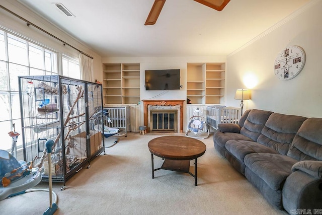 327 N Holloway Ave, El Dorado, AR 71730 - carpeted living room with built in features, a glass covered fireplace, a ceiling fan, and crown molding