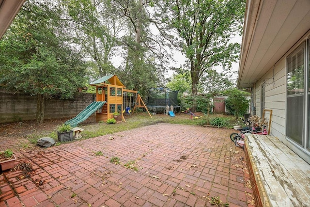 327 N Holloway Ave, El Dorado, AR 71730 - fenced backyard with a patio, a playground, and a trampoline
