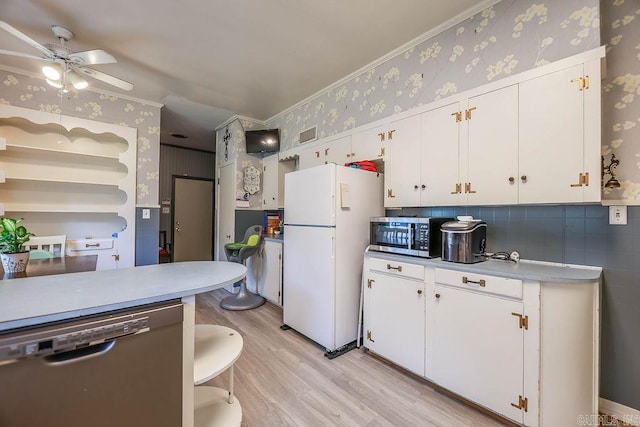 327 N Holloway Ave, El Dorado, AR 71730 - kitchen featuring stainless steel appliances, wallpapered walls, light wood-style floors, white cabinets, and ceiling fan