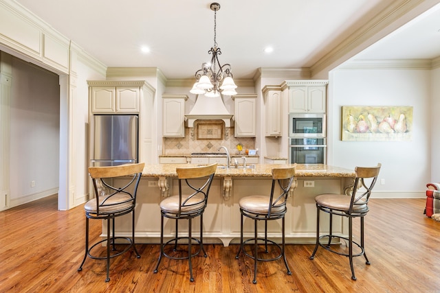 4 Bellegarde Dr, Little Rock, AR 72223 - kitchen with stainless steel appliances, decorative backsplash, premium range hood, light stone counters, and a large island