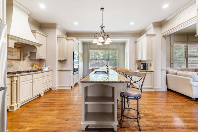 4 Bellegarde Dr, Little Rock, AR 72223 - kitchen with stainless steel appliances, a sink, a center island with sink, decorative backsplash, and custom range hood