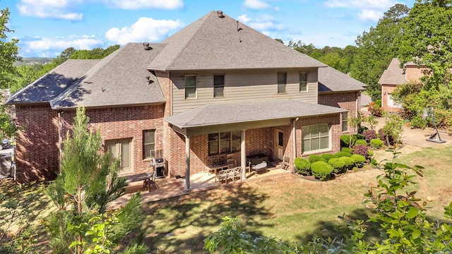 4 Bellegarde Dr, Little Rock, AR 72223 - back of house featuring brick siding, a patio area, a yard, and roof with shingles