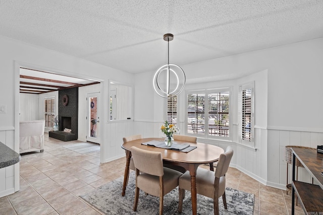 50 Heritage Park Cir, North Little Rock, AR 72116 - dining room featuring light tile patterned floors, a fireplace, a wainscoted wall, and a textured ceiling