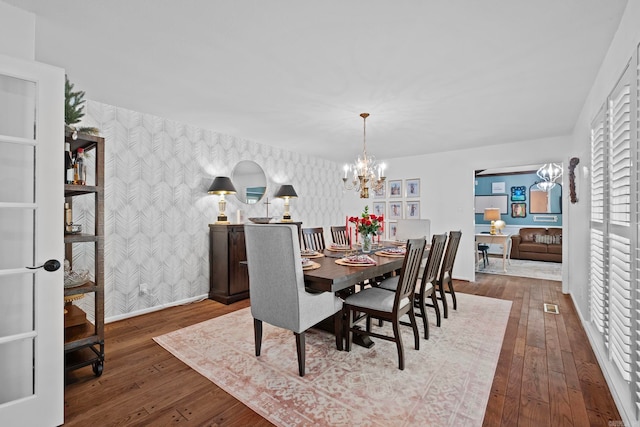 50 Heritage Park Cir, North Little Rock, AR 72116 - dining room with wallpapered walls, a chandelier, an accent wall, baseboards, and hardwood / wood-style floors