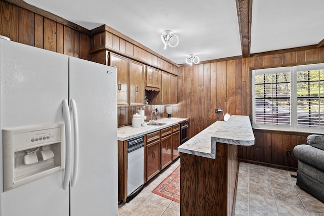 50 Heritage Park Cir, North Little Rock, AR 72116 - kitchen featuring white fridge with ice dispenser, wooden walls, light countertops, a sink, and beamed ceiling