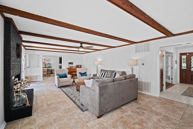 50 Heritage Park Cir, North Little Rock, AR 72116 - living room featuring a decorative wall, a fireplace, ceiling fan, beamed ceiling, and light tile patterned flooring