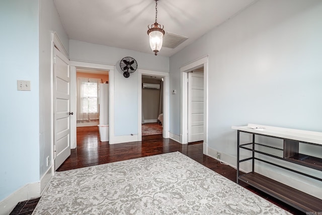 321 Hazel St, Hot Springs, AR 71901 - bedroom with wood finished floors, a wall unit AC, and baseboards
