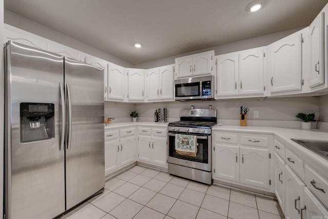306 Ray St, Cabot, AR 72023 - kitchen featuring stainless steel appliances, white cabinets, light tile patterned floors, light countertops, and recessed lighting