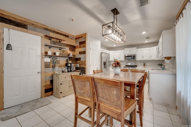 306 Ray St, Cabot, AR 72023 - dining space featuring light tile patterned floors, wooden walls, and recessed lighting