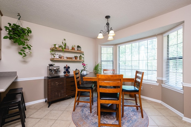 2418 Hickorynut Ct, Little Rock, AR 72211 - dining room with light tile patterned floors, plenty of natural light, a textured ceiling, a chandelier, and baseboards