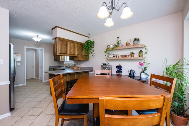 2418 Hickorynut Ct, Little Rock, AR 72211 - dining space with a chandelier, light tile patterned flooring, baseboards, and a textured ceiling