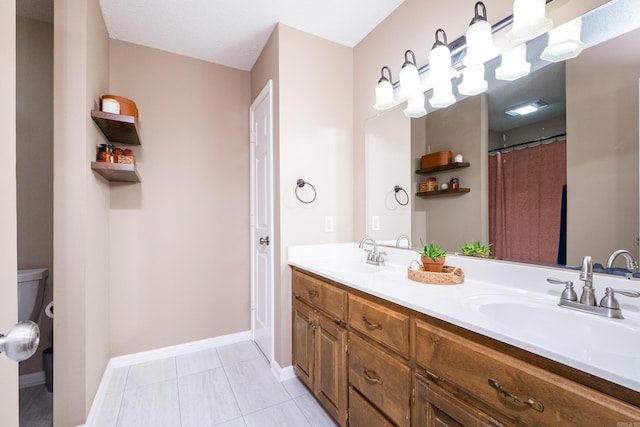 2418 Hickorynut Ct, Little Rock, AR 72211 - bathroom featuring double vanity, baseboards, and toilet