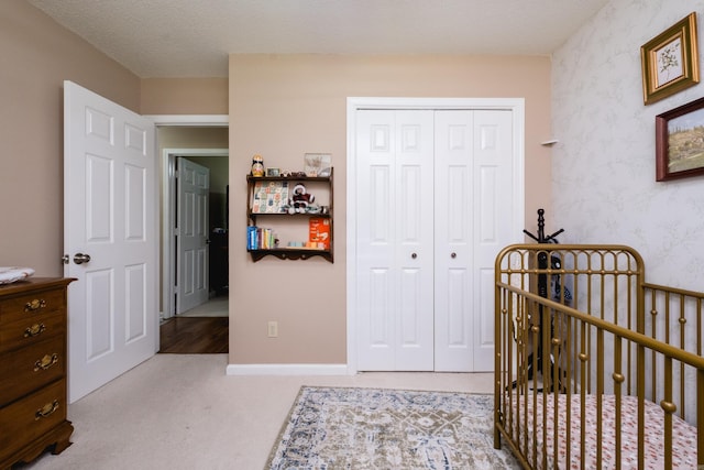 2418 Hickorynut Ct, Little Rock, AR 72211 - carpeted bedroom featuring a closet, wallpapered walls, and a nursery area