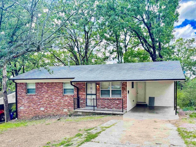 704 W 56th St, North Little Rock, AR 72118 - ranch-style house with concrete driveway, brick siding, an attached carport, roof with shingles, and a porch