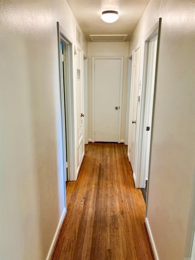 704 W 56th St, North Little Rock, AR 72118 - corridor featuring wood finished floors, attic access, and baseboards