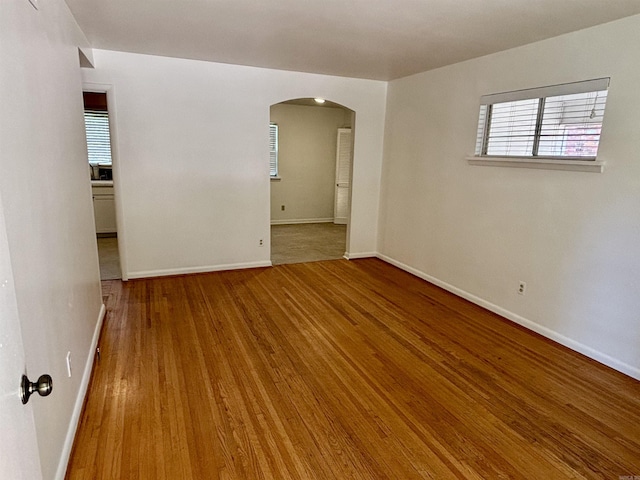704 W 56th St, North Little Rock, AR 72118 - empty room with arched walkways, wood finished floors, and baseboards