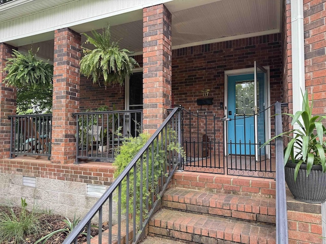property entrance featuring crawl space and brick siding