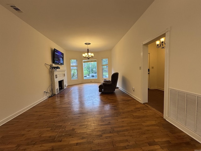 unfurnished room featuring a chandelier, dark wood-style floors, baseboards, and a fireplace