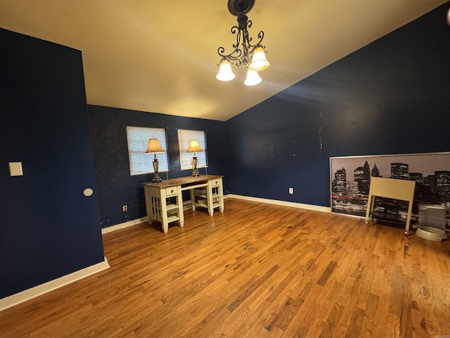 office area featuring wood finished floors, lofted ceiling, a chandelier, and baseboards