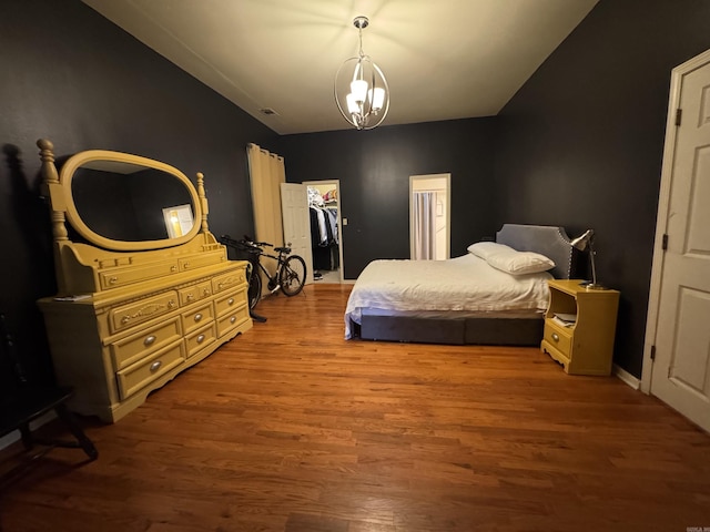 bedroom with wood finished floors, a spacious closet, and a closet