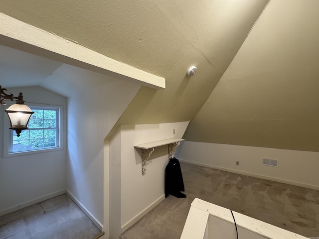 additional living space with vaulted ceiling, baseboards, and light colored carpet