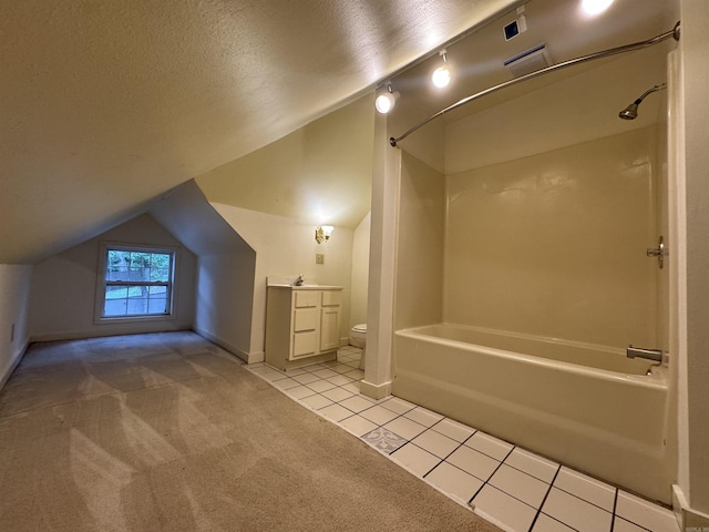 bathroom featuring lofted ceiling, shower / bath combination, toilet, tile patterned flooring, and vanity