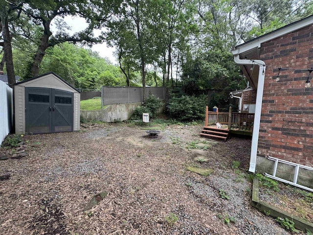 view of yard with a wooden deck and an outdoor fire pit