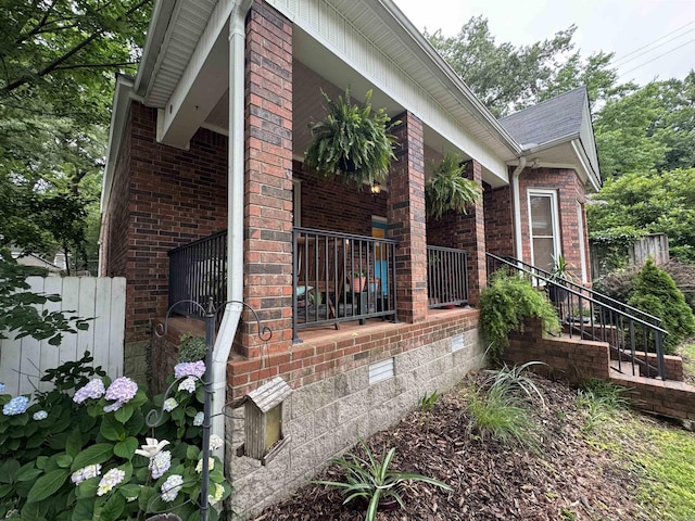 view of home's exterior featuring brick siding, crawl space, and a porch