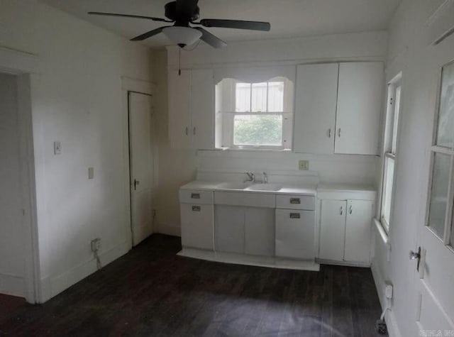 1700 Moss St, North Little Rock, AR 72114 - kitchen with a sink, a ceiling fan, light countertops, white cabinets, and dark wood finished floors