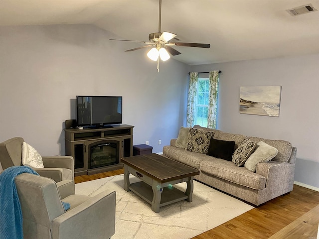 192 Shady Grove, Clarksville, AR 72830 - living room with light wood-type flooring, a ceiling fan, vaulted ceiling, a glass covered fireplace, and baseboards