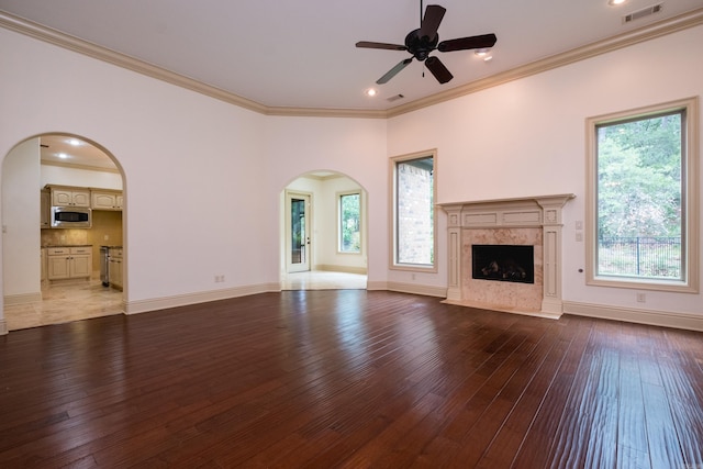 28 Talmont Pl, Little Rock, AR 72223 - unfurnished living room featuring arched walkways, hardwood / wood-style flooring, a ceiling fan, ornamental molding, and a premium fireplace